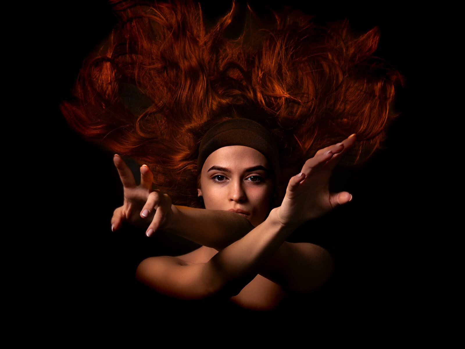 Photo by Marcin Sajur Woman with flowing red hair and crossed arms.