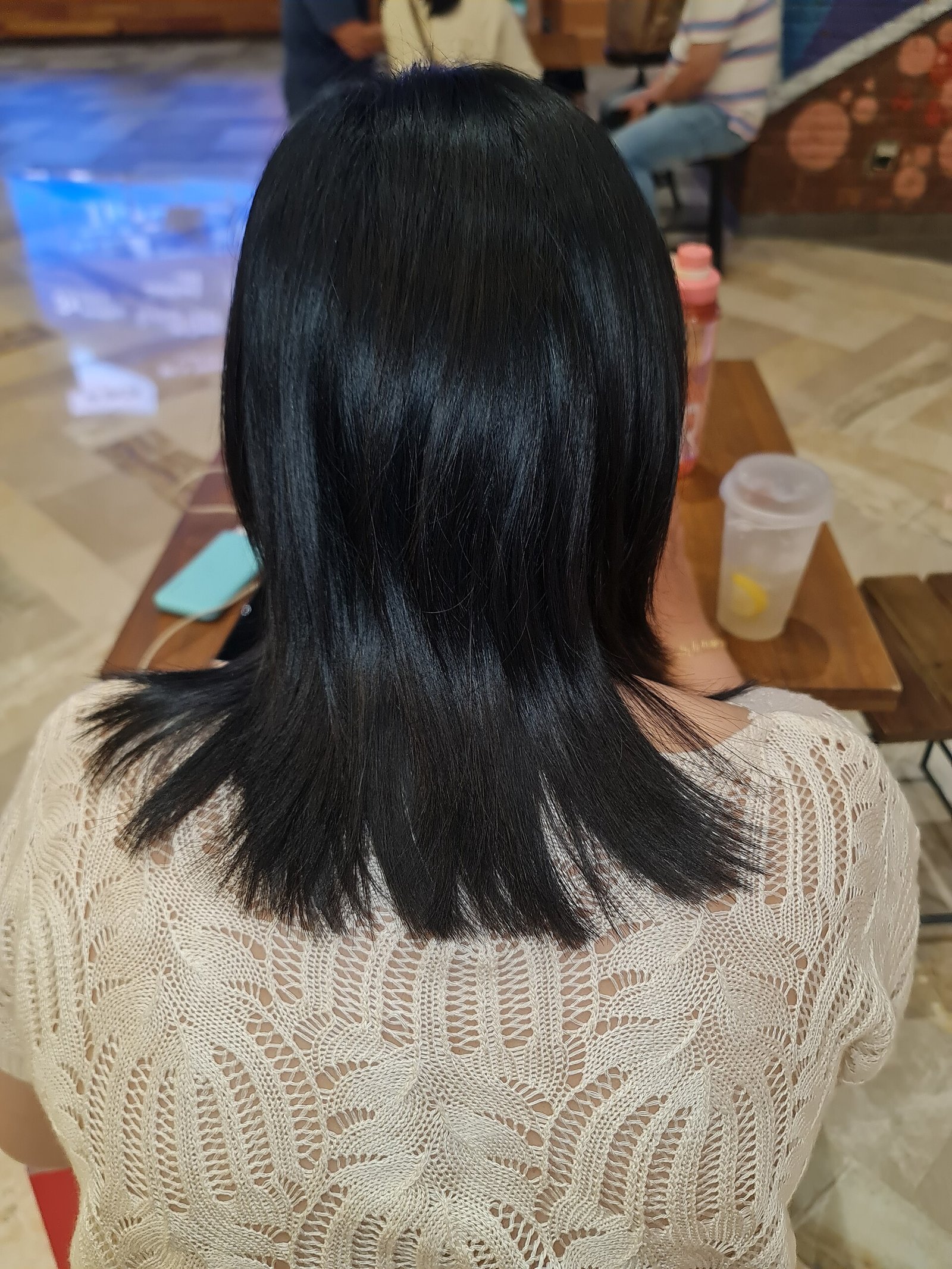 girlook-5 Femme vue de dos aux longs cheveux noirs et lisses, portant un pull en maille