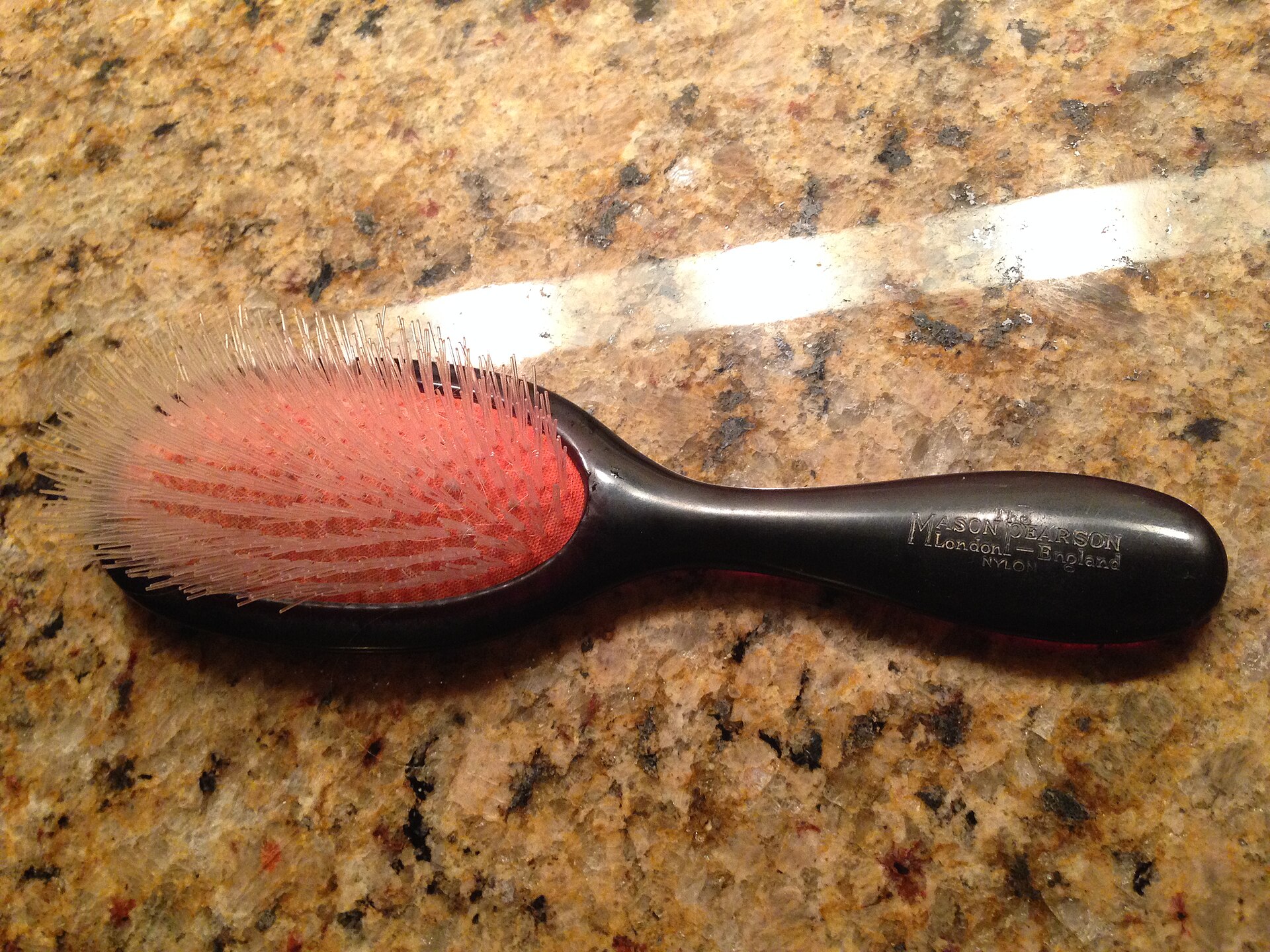 n2-girlook Brosse à cheveux ovale à poils fins posée sur une surface en granit